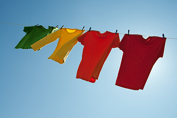 Image showing Colorful clothes hanging to dry in the blue sky