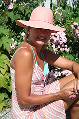 Image showing Smiling girl among roses