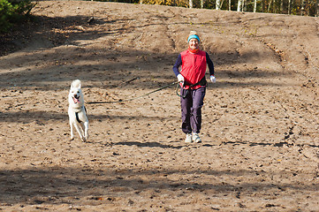 Image showing Running the sports woman with a dog