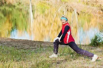 Image showing The woman does sports exercises in autumn park