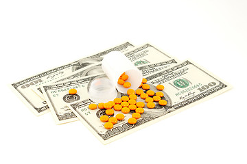 Image showing orange pill at the money , isolated on white background 