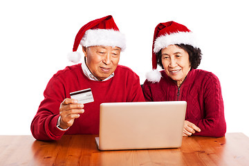 Image showing Senior Asian couple shopping online celebrating Christmas