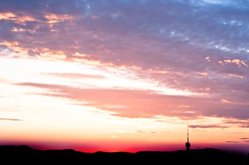 Image showing Evening scene of an urban area with red clouds and silhouettes o