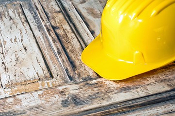 Image showing Yellow helmet on burnt wooden log