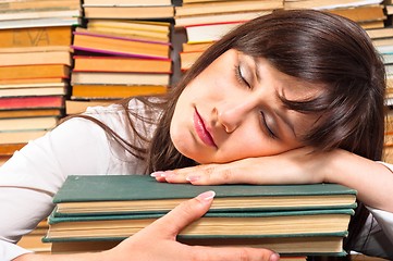 Image showing Overworked university student sleeping on her books