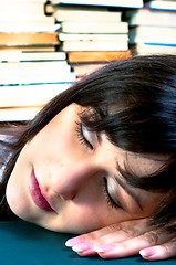 Image showing Student girl sleeping on her books