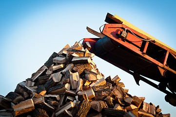 Image showing Firewood comes out of a machine