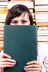 Image showing Student girl hiding behind big book