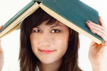 Image showing Young university student with a book on her her against white is