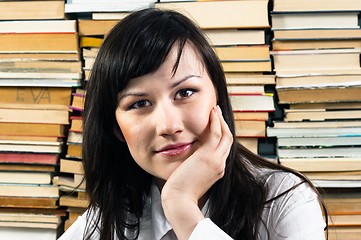 Image showing Young student thinking against piled up books