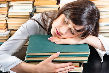 Image showing Young university student sleeping on books