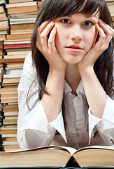 Image showing Young student reading a book in the library