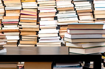 Image showing Books piled up against black desk