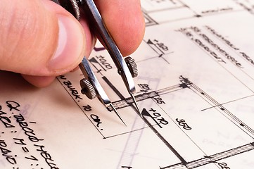 Image showing Compass in hand with construction plans