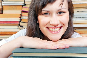 Image showing Cheerful young university student  and her books