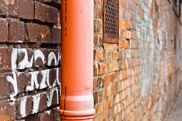 Image showing Sewage pipe on brick abandoned wall