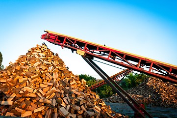 Image showing Firewood comes out of a machine