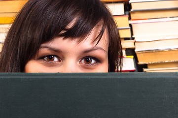 Image showing Girl hiding behind book with blurry background