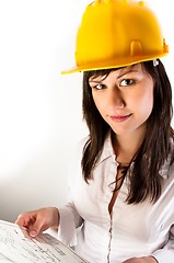 Image showing Pretty business woman in yellow helmet holding her plans