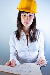 Image showing Engineer woman in yellow helmet with plans