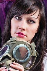 Image showing Portrait of a young woman holding her gasmask tight