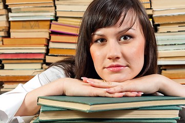 Image showing Portrait of a young student against piled up books