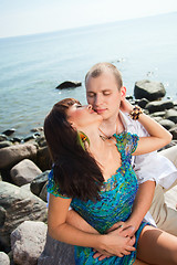 Image showing Kiss of loving couple near of blue sea