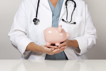 Image showing Doctor with Stethoscope Holding Piggy Bank Abstract