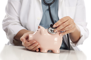 Image showing Doctor Holding Stethoscope to Piggy Bank