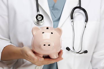 Image showing Doctor with Stethoscope Holding Piggy Bank Abstract