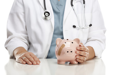 Image showing Doctor Holding Caring Hand on a Piggy Bank with Bandage