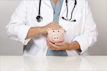 Image showing Doctor with Stethoscope Holding Piggy Bank Abstract