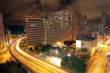 Image showing blurred bus light trails in downtown night-scape 