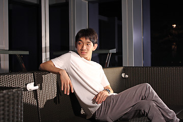 Image showing Man sit on a bench while relaxing at a pub. 