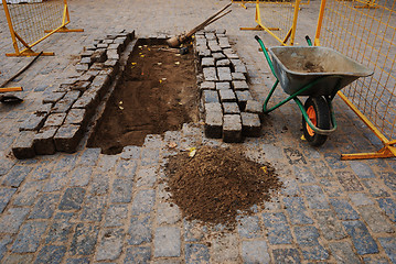 Image showing stones, a wheelbarrow, and tools for paving 