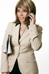 Image showing Businesswoman on phone with newspaper under arm