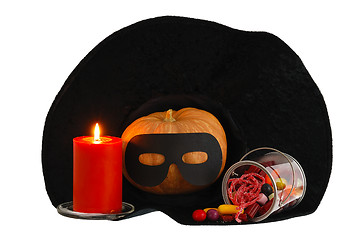 Image showing Halloween candies with candle and  pumpkin in witch hat isolated