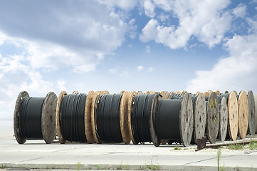 Image showing Large rolls of black cables