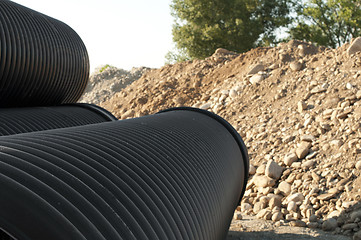 Image showing Pipes and piles of sand in the background