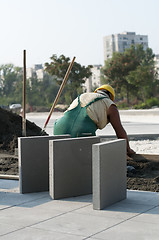 Image showing A worker puts exterior tiles 