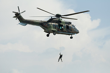 Image showing Soldier hanging from a helicopter