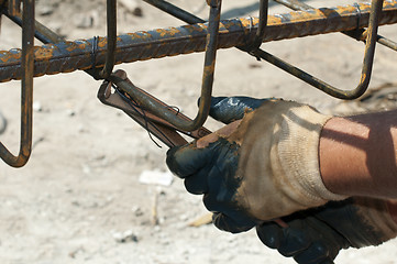 Image showing Construction worker ties reinforcing steel