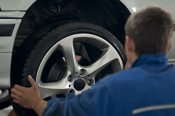 Image showing Mechanic put a car tire