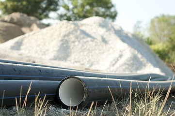 Image showing Pipes and piles of sand in the background