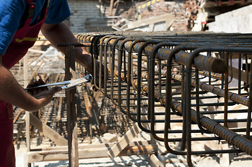 Image showing Construction worker ties reinforcing steel