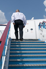 Image showing Businessman who climbs on plane