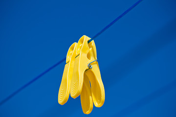 Image showing cloth pegs under the clear blue sky