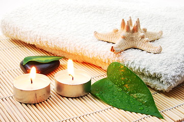 Image showing foldet white bath towel and zen stones