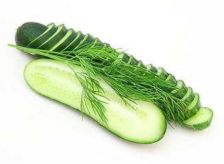 Image showing a cucumber with the cut half lying on a dill