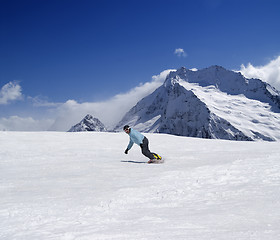 Image showing Snowboarder descends a slope